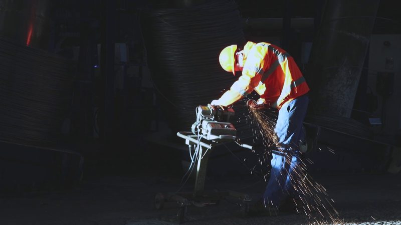 Barnfather Wire worker grinding wire in factory with sparks